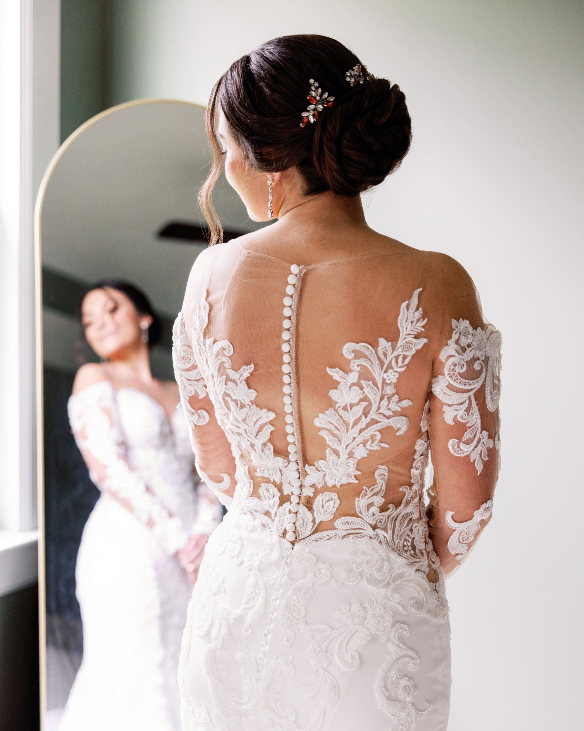bride getting ready in lace wedding dress by window pittsburgh wedding photographer