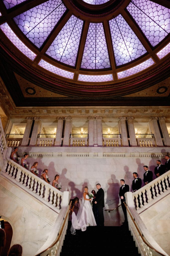 Wedding ceremony on grand staircase at Renaissance Hotel Pittsburgh with guests lined along balcony