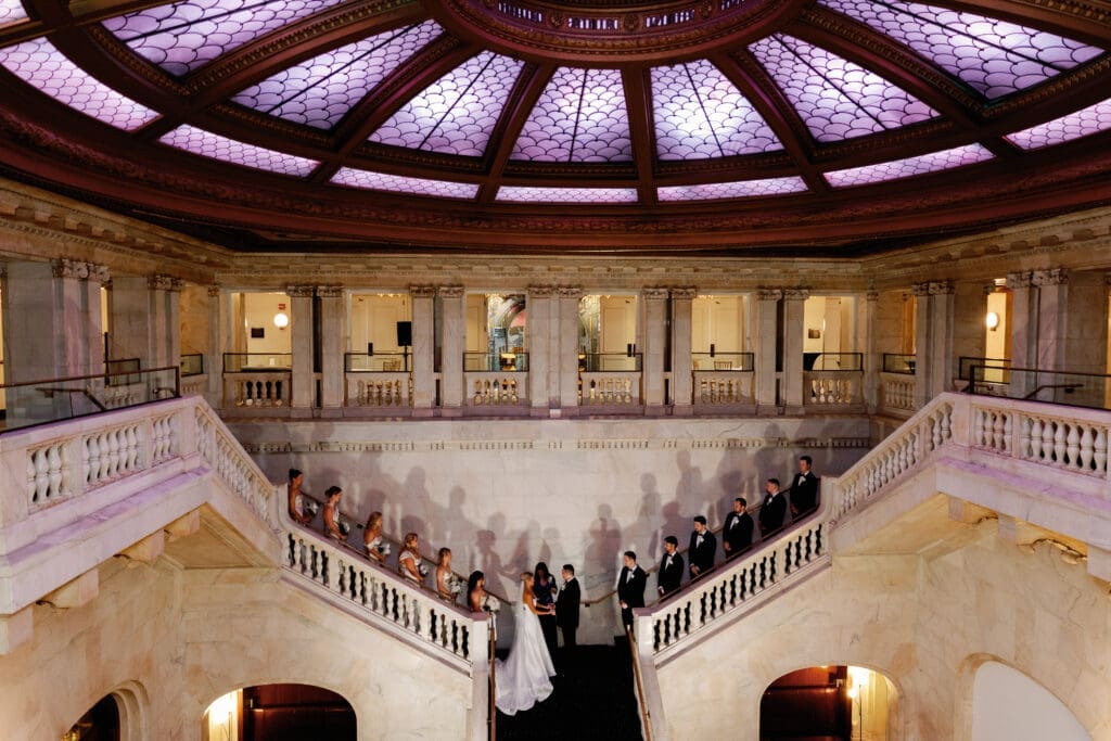 Wide view of wedding ceremony on staircase under domed ceiling at Renaissance Hotel Pittsburgh
