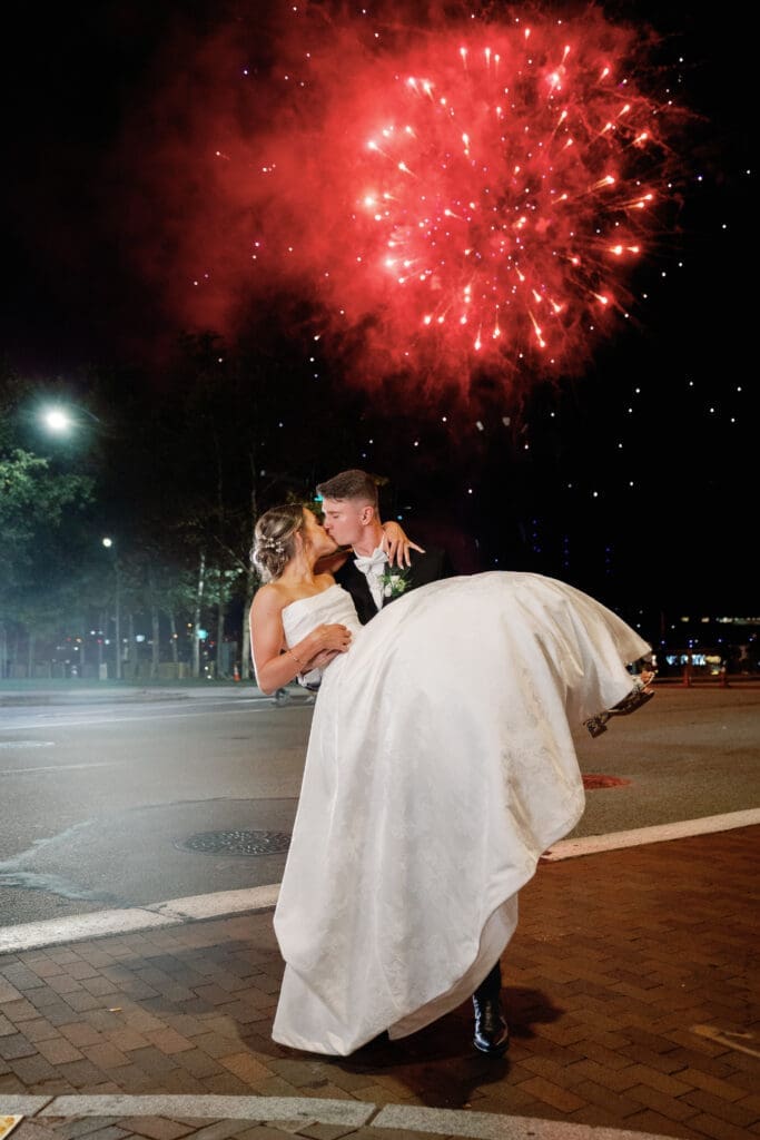 Bride and groom kissing under fireworks outside Renaissance Hotel Pittsburgh wedding