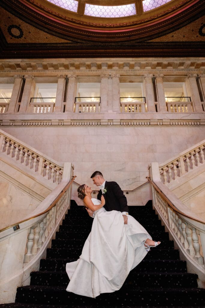Bride and groom sharing dip kiss on iconic staircase at Renaissance Hotel Pittsburgh wedding