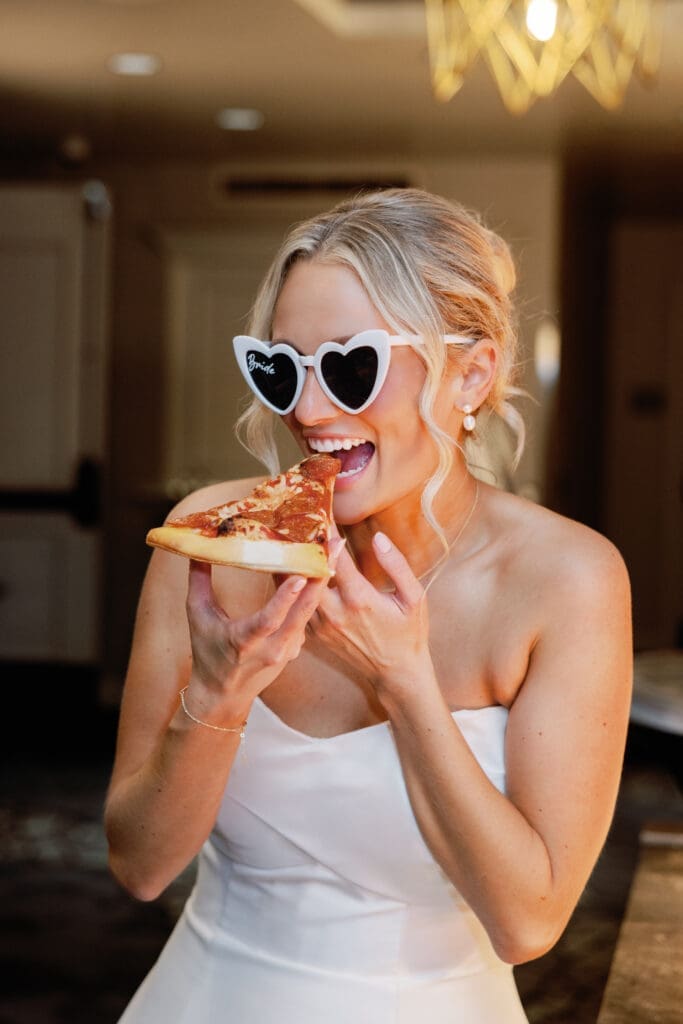 Bride eating pizza on dance floor during fun Renaissance Hotel Pittsburgh wedding
