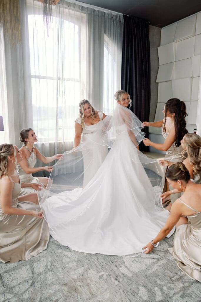 Bridesmaids helping bride with veil in elegant getting ready suite at Renaissance Hotel Pittsburgh
