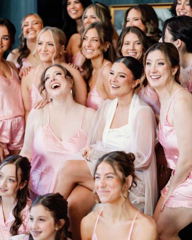 Bride surrounded by bridesmaids in pink dresses during getting ready moments at Renaissance Hotel Pittsburgh