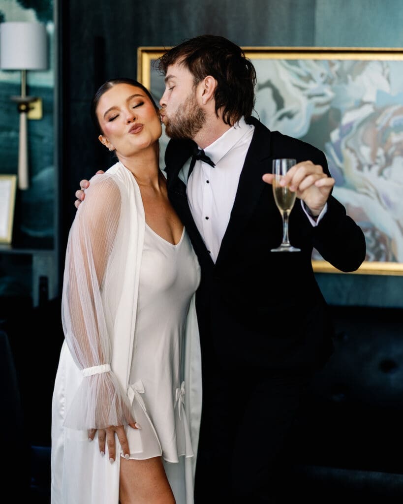 Bride and groom celebrating with champagne in Renaissance Hotel Pittsburgh getting ready suite